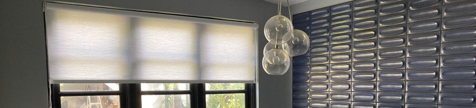 Bathroom window in San Marcos with custom sheer window shades half open, allowing sunlight while maintaining a cozy atmosphere.