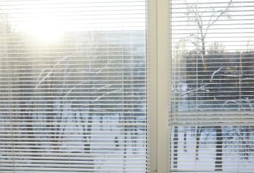Detail of mini blinds installed in a cozy home environment, enhancing privacy and style.