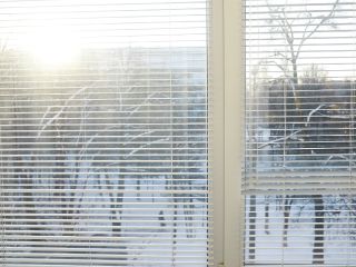 Detail of mini blinds installed in a cozy home environment, enhancing privacy and style.